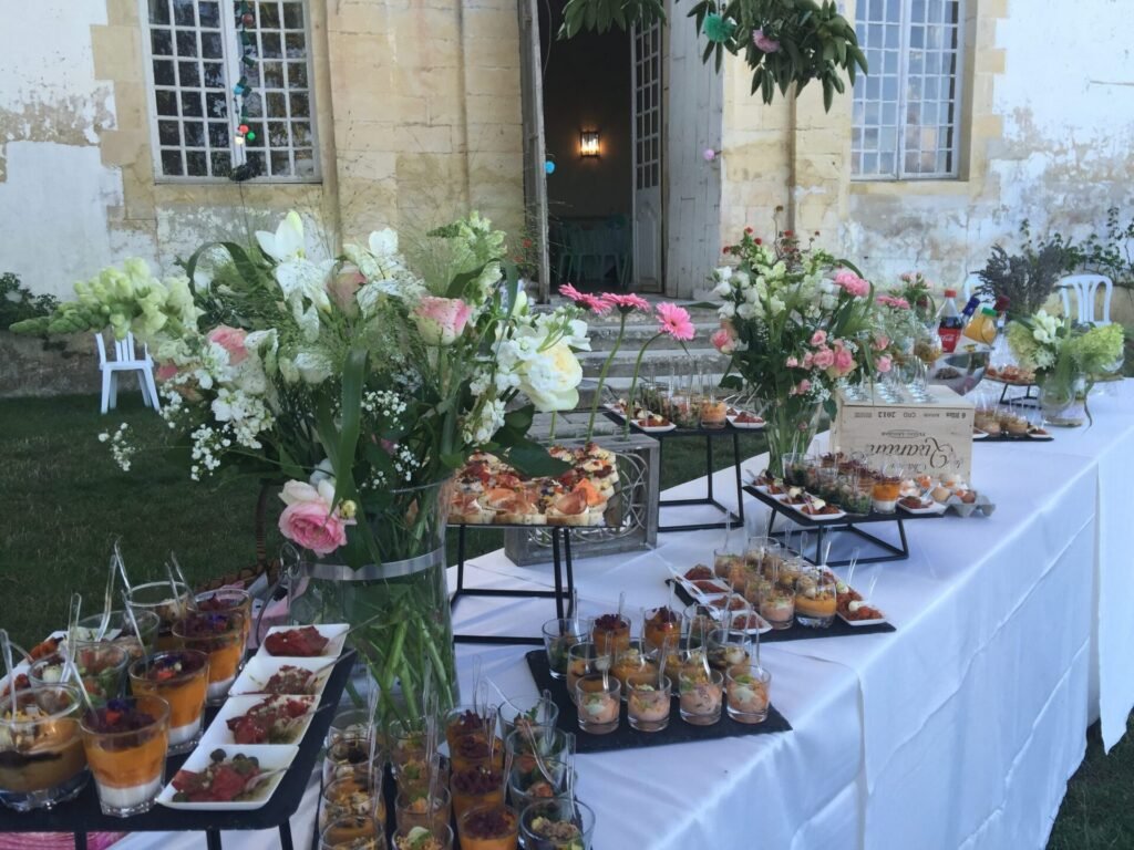 Buffet dressé avec des fleurs blanches dans une cour en pierre