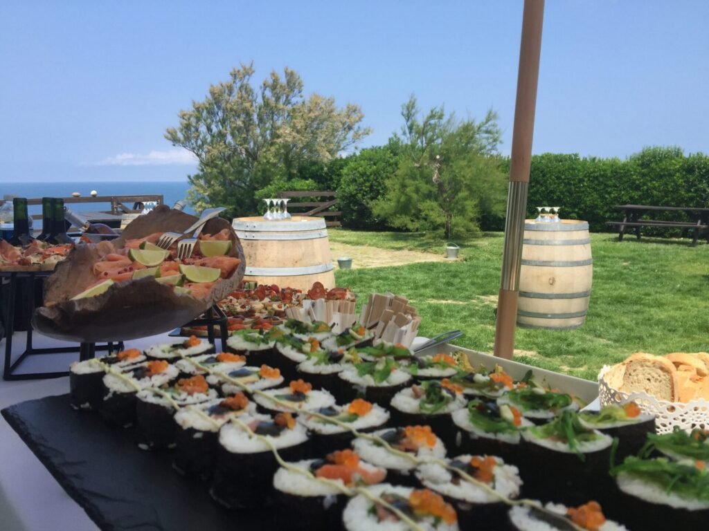 Buffet de makis et de saumon dressé en extérieur face à l’océan