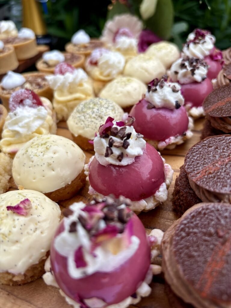 Rangées de mignardises et de pâtisseries dressées sur ardoise