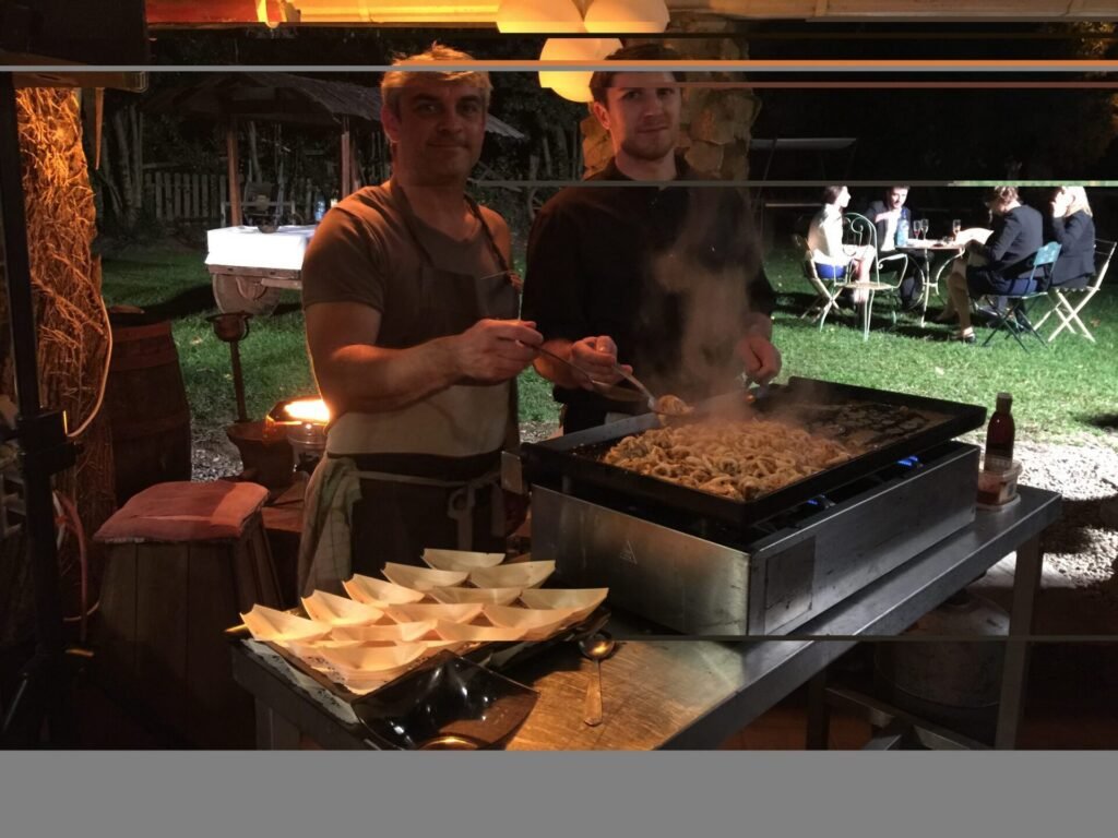 Stéphane Lafitte cuisinant à la plancha pendant une réception en soirée